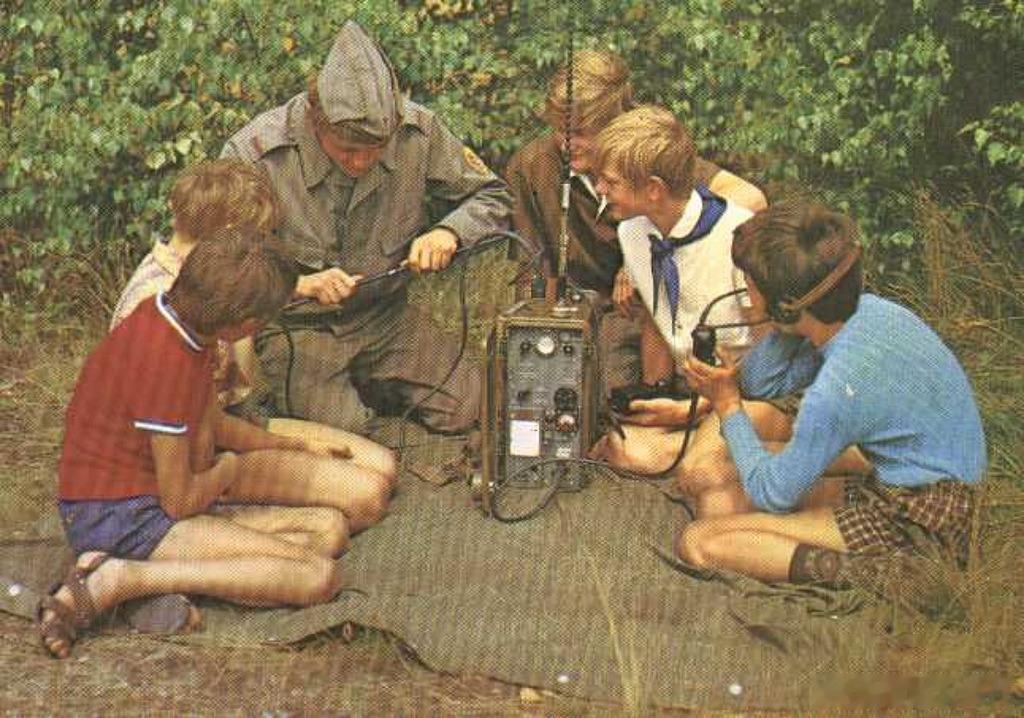 1980年代，一名士兵正在向自由德国青年联盟（FDJ）的少年成员示范如何操作野战