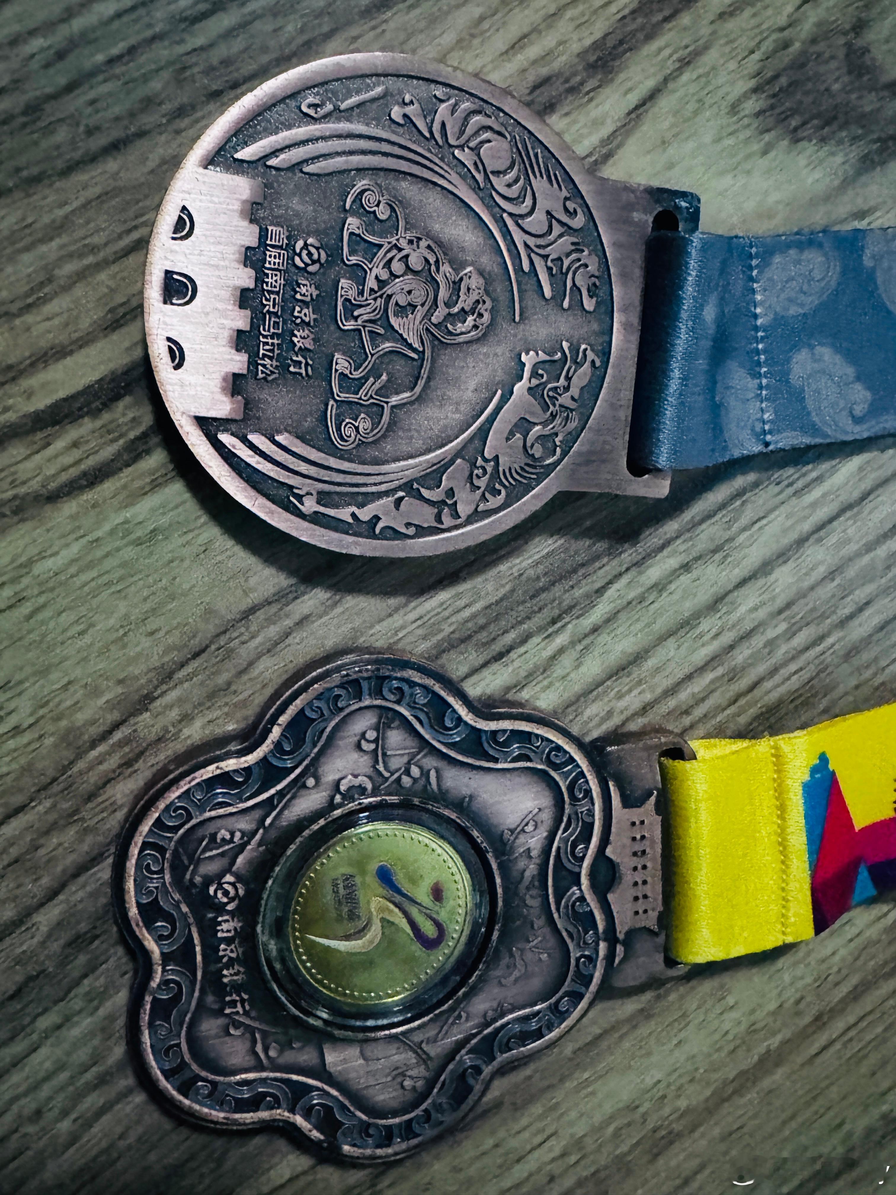 家里翻到了2015和2016南京马拉松的奖牌，依然记得最初两届南马风评很差，骂声