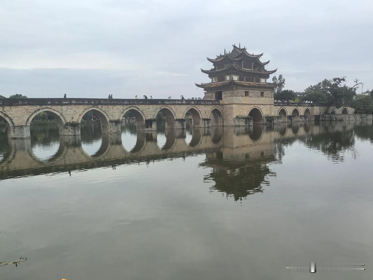 七律·双龙桥
遐迩驰声双龙桥，
双阁十七拱横霄。
建水城西五里遥，
泸塌合处水相
