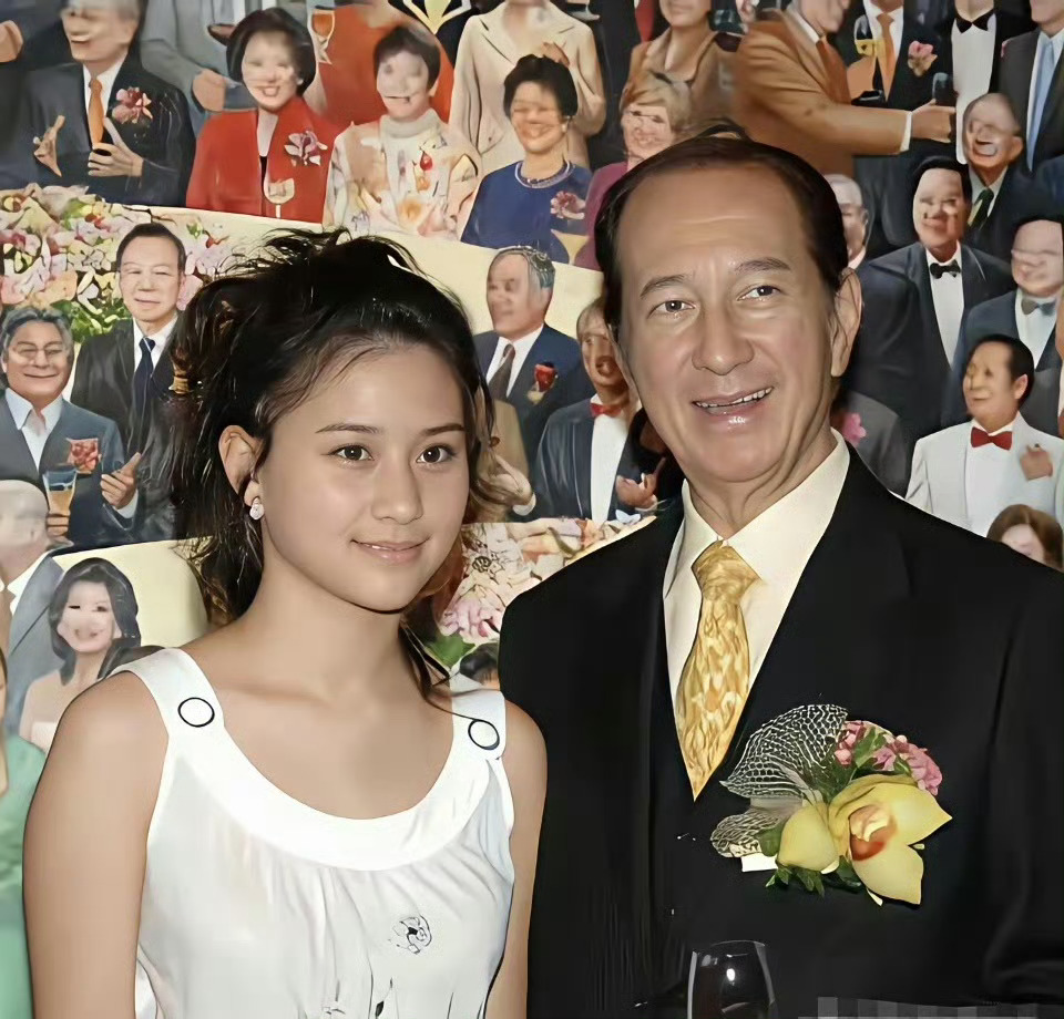 少女时期的何超莲，和爸爸赌王一起拍照，个子小小的，脸蛋圆圆的，看起来还没长开 