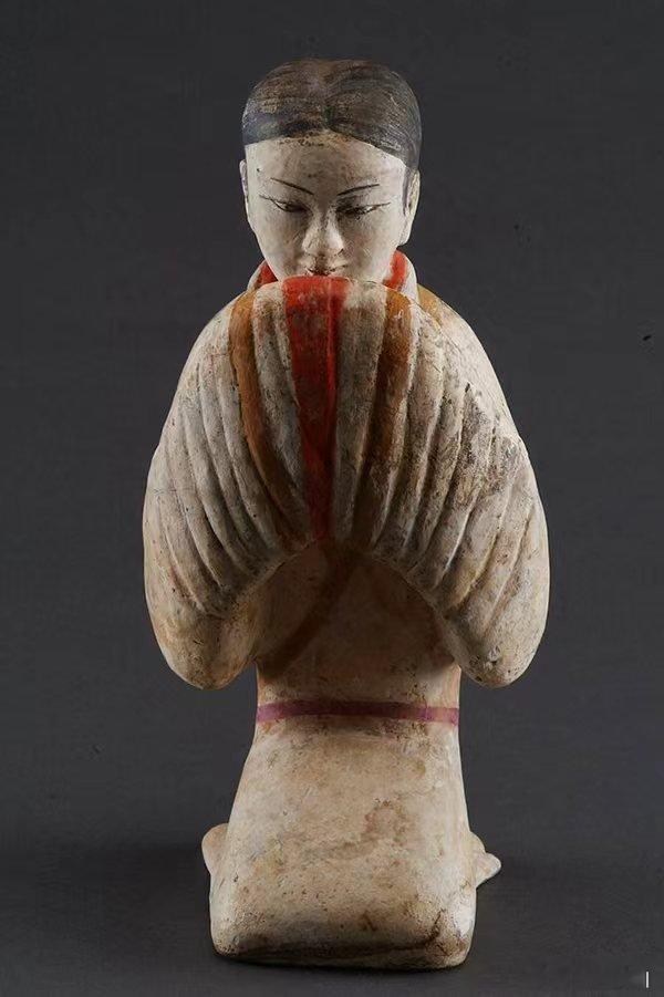 中国最初的微笑汉景帝陪葬墓出土的跽坐陶俑，特别是其中的塑衣式彩绘拱手跽坐女俑，是