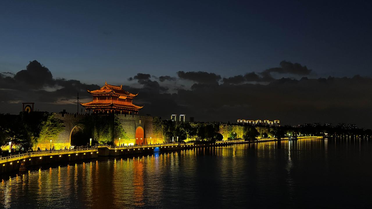 古城美图暮色垂落，灯火点亮古城门楼。河水漫过岁月，把满城流光，揉碎在波光之间。