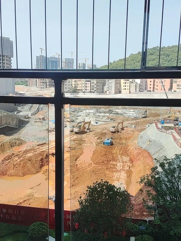 城市建设中的忙碌景象，挖掘机轰鸣声中，高楼拔地而起。