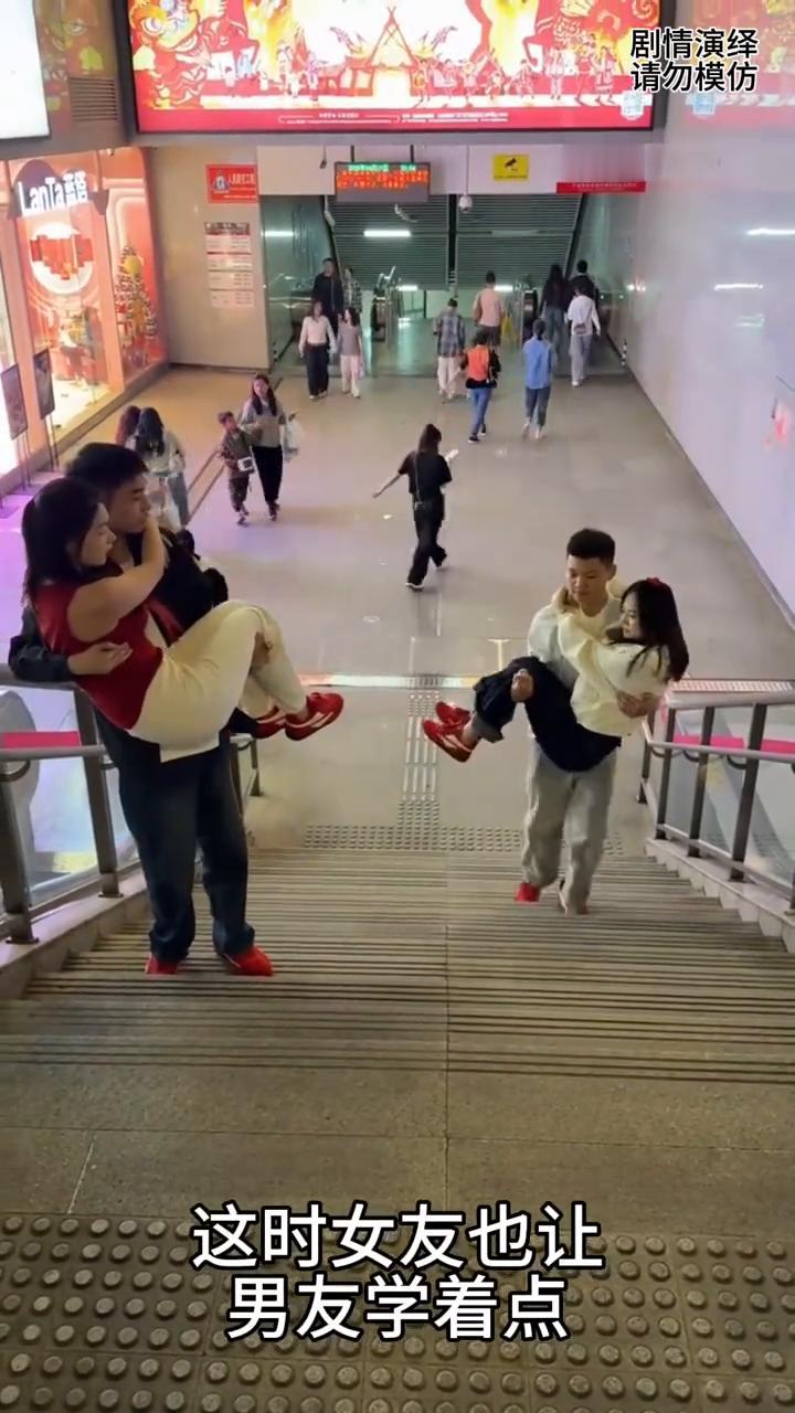 情人节的互相攀比。
今天是情人节，只见男子抱着女友上台阶，旁边一对情侣正好碰到，