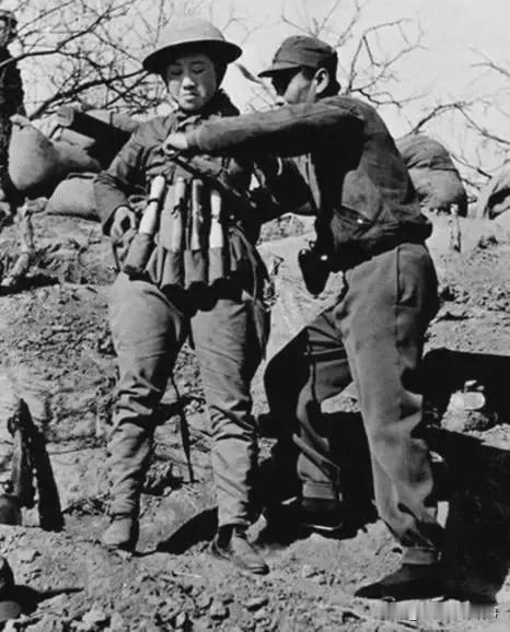 1938年春，台儿庄的烽火映照着一位女勇士的身影。这位女勇士正在战友的协助下，将