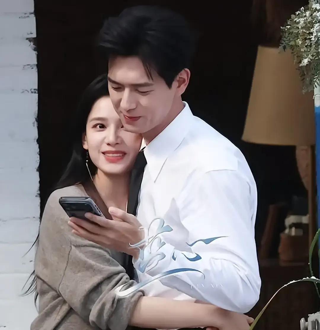 李现片场刚收工，没回房车，直接掏出手机对张婧仪说，来，给你拍几张。半蹲、调光、指