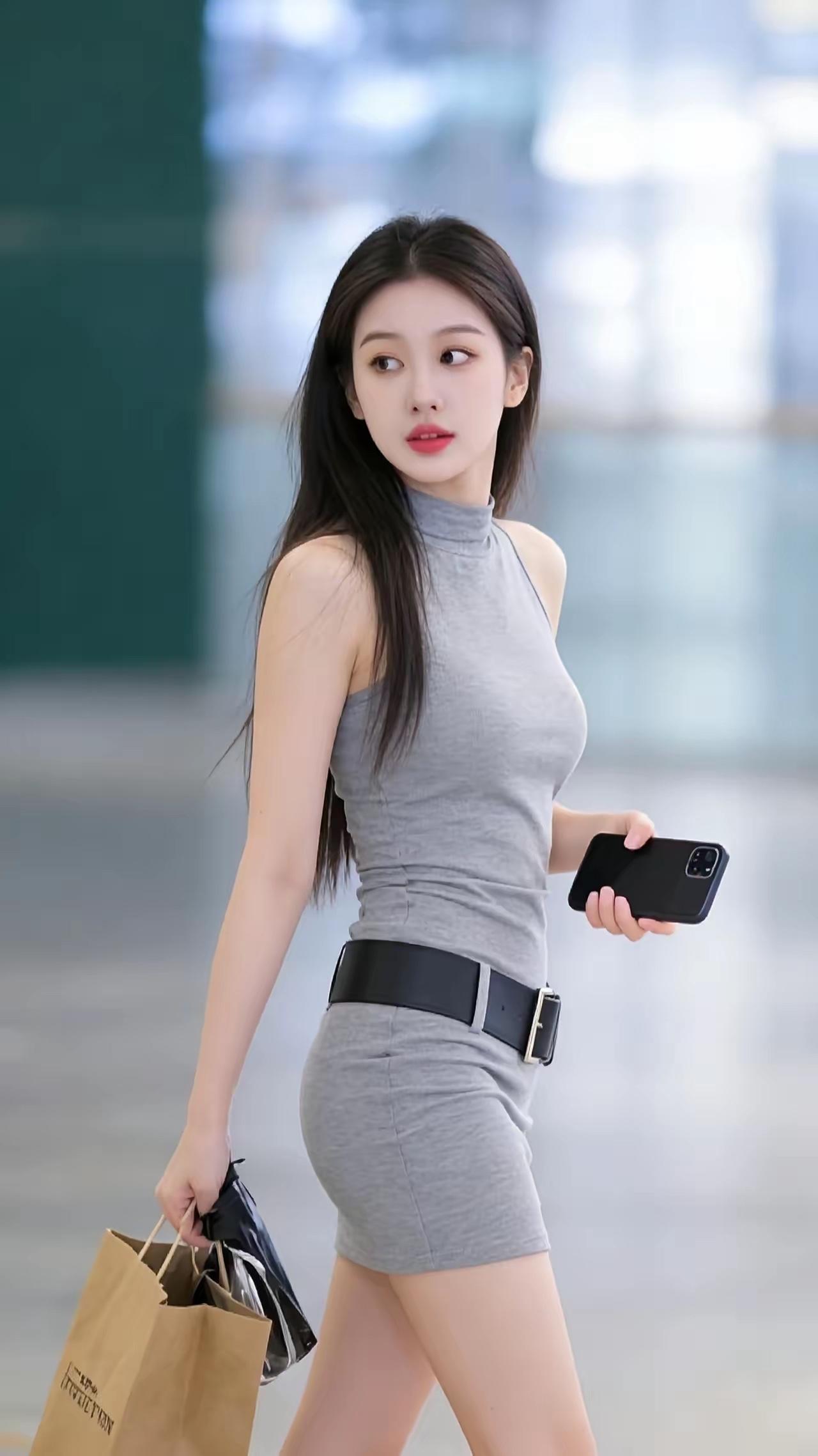 都市时尚女孩，灰色连衣裙搭配黑色腰带，手机在手，自信满满！