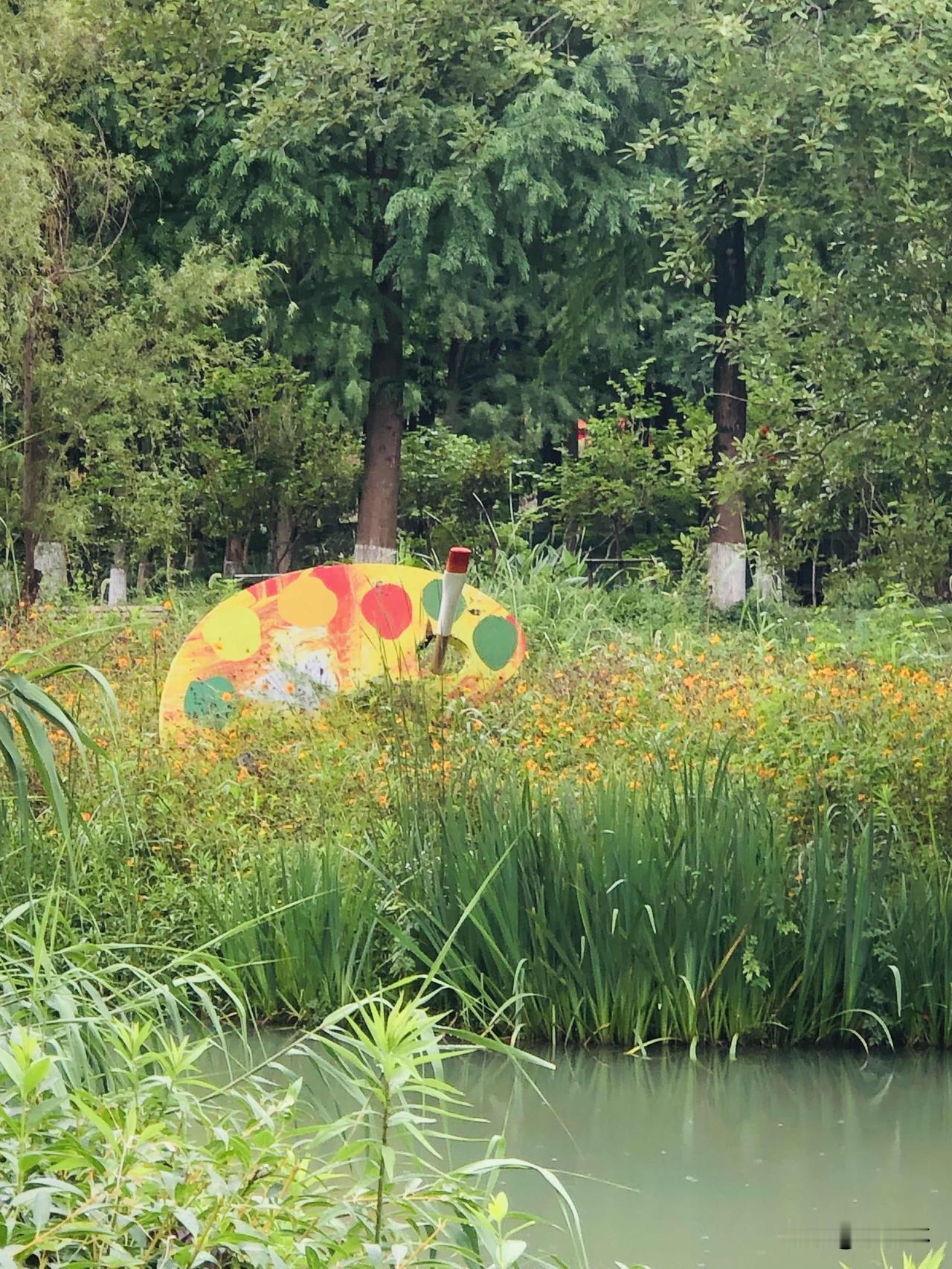 由于台风影响，一场夏雨过后，公园格外清爽。湿漉漉的小路绿树成荫，河面平静，小花船