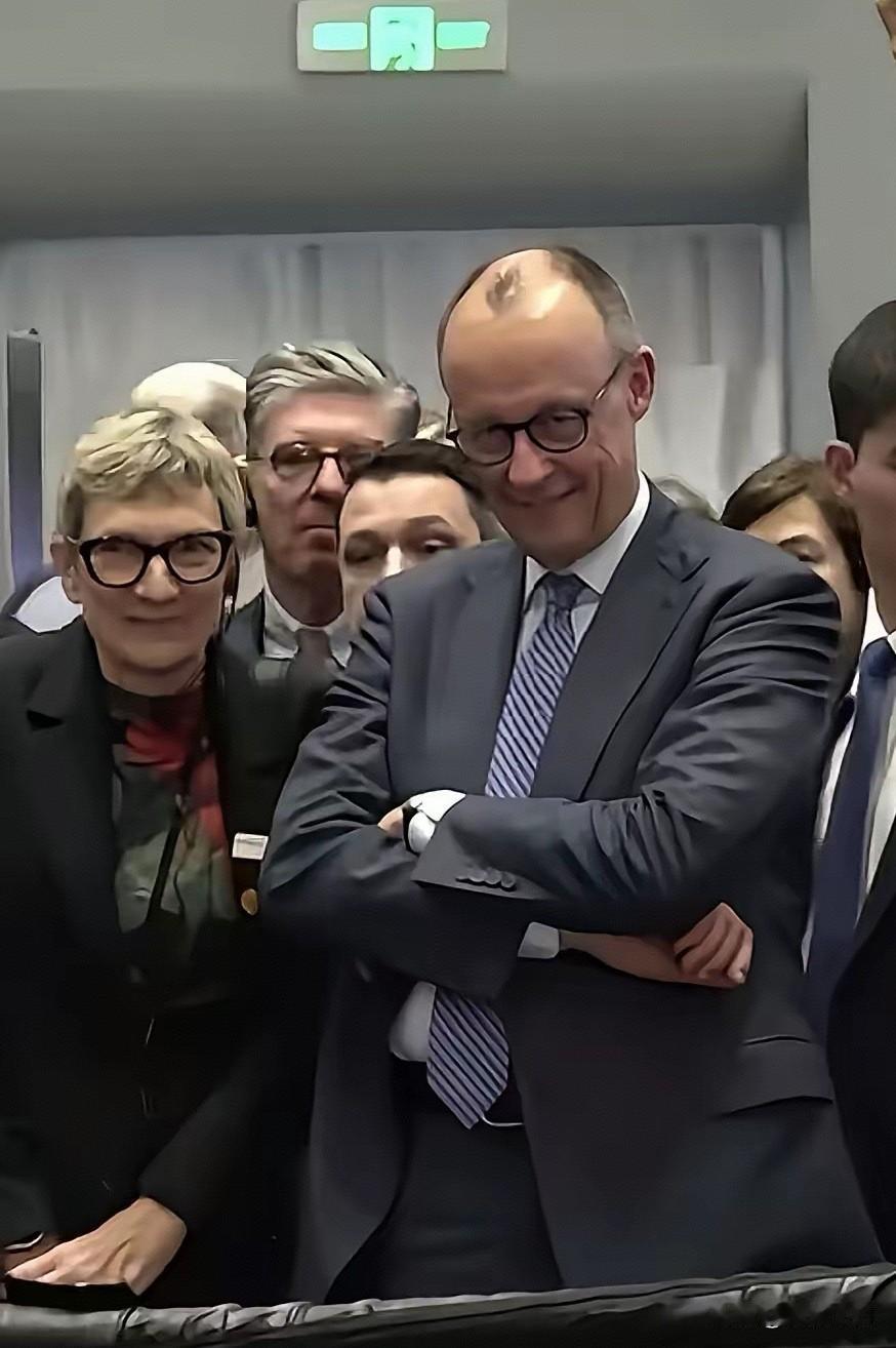 专家：默茨参观宇树机器人的表情引关注。
网友：默茨个子太高，机器人体型矮，目光俯