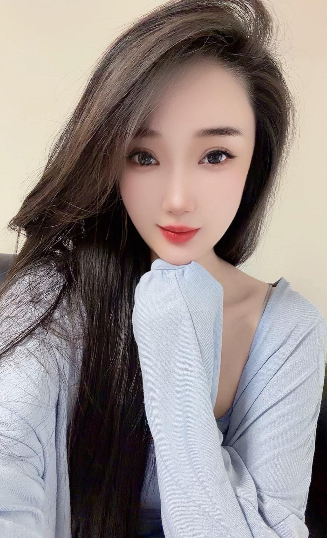 温柔甜美的少女，浅蓝色毛衣，自然妆容，微笑迷人。
