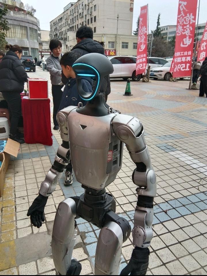 你看这街头突然冒出来的机器人，也太吸睛了吧！

银灰色的金属机身，脑袋上还带着一