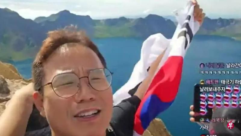 一名韩国网红在登上中国长白山天池景区时，拿出韩国国旗挥舞并唱韩国国歌，被中国警方