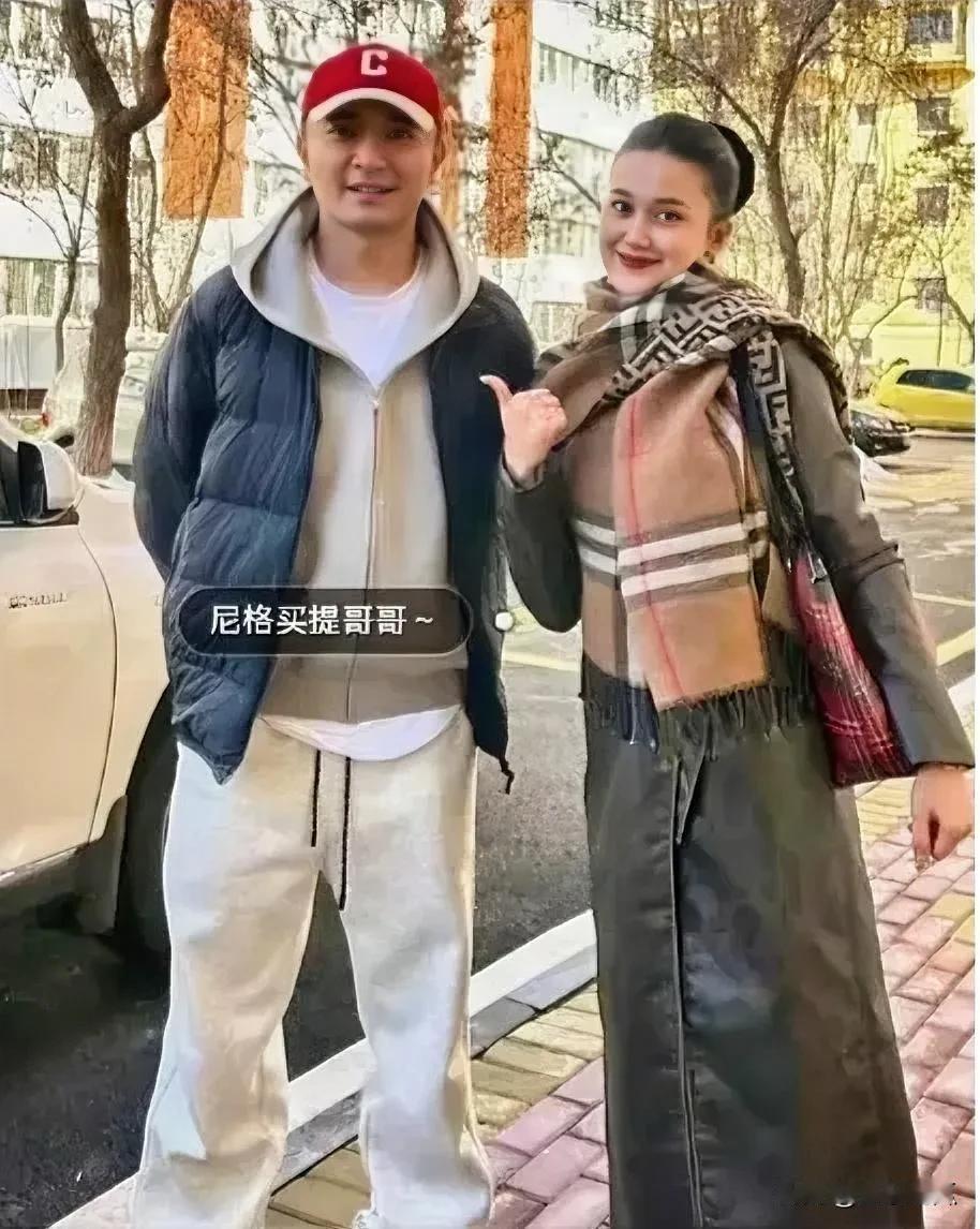 主持人尼格买提和妹妹在家乡的一张合照，满是亲情感，两人脸上洋溢着灿烂的笑容。
尼