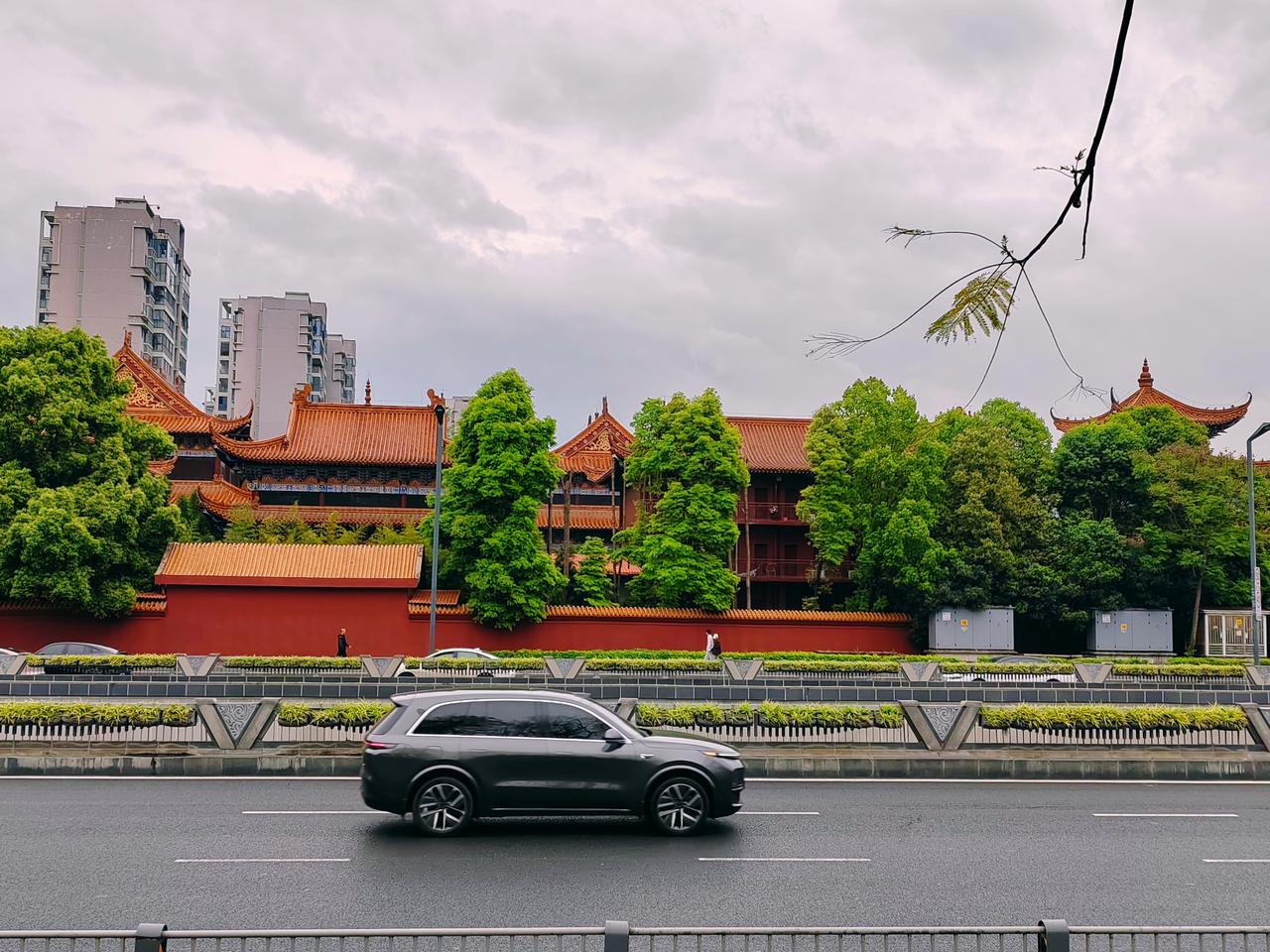 红墙黛瓦在车流旁静静伫立，现代的喧嚣与古建的静谧在此温柔相融。行过车水马龙，偶遇