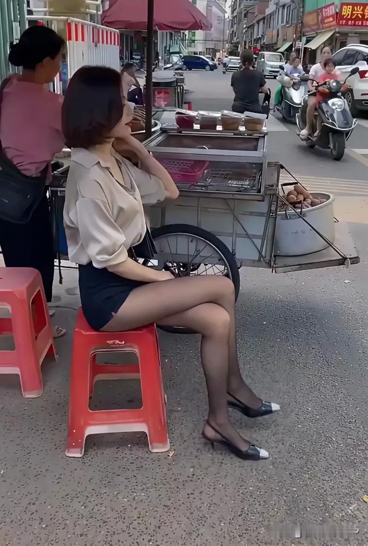 美女在傍边看小吃摊，也是发愁啊，为什么就没有顾客来消费生意呢？

这年头出来摆摊