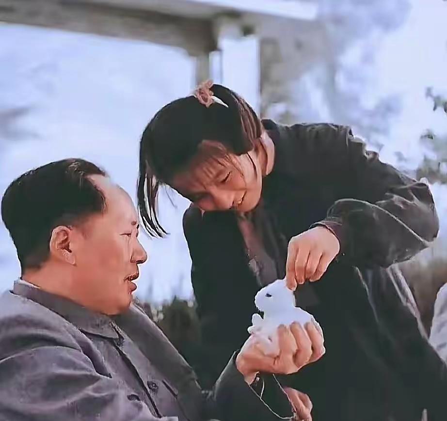 毛主席稳坐在木椅上，掌心轻轻托着一只雪白温顺的小白兔，李讷小手轻轻抓着兔子长长的