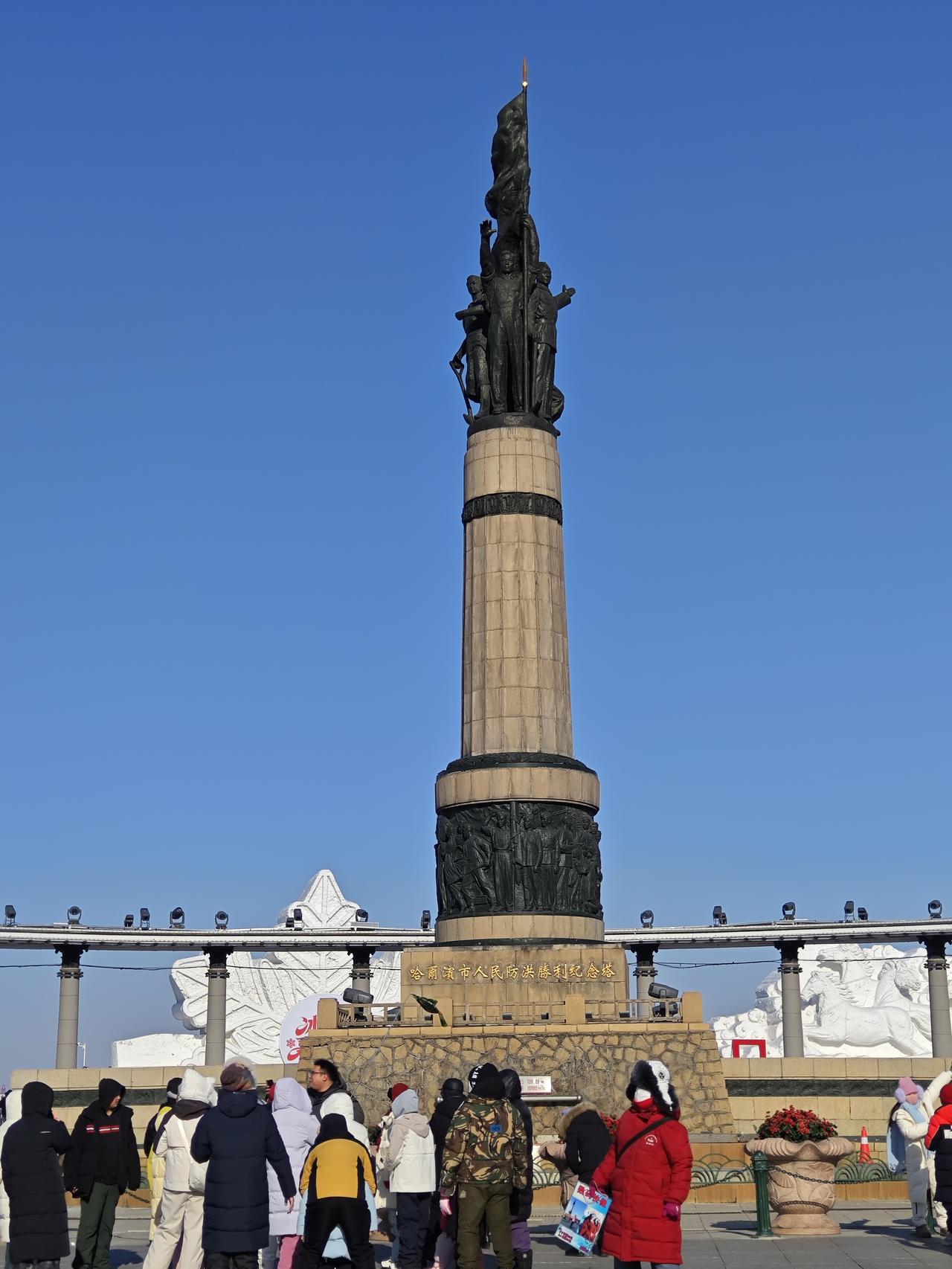 分享一张最近随手拍的照片在哈尔滨的晴空下，防洪纪念塔静静矗立，青铜雕塑与米黄色柱