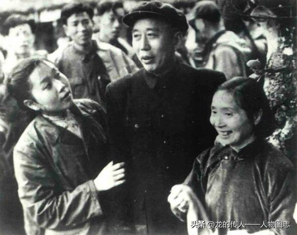 王震在广东省农垦厅副厅长危秀英(右)陪同下和农场职工亲切交谈。