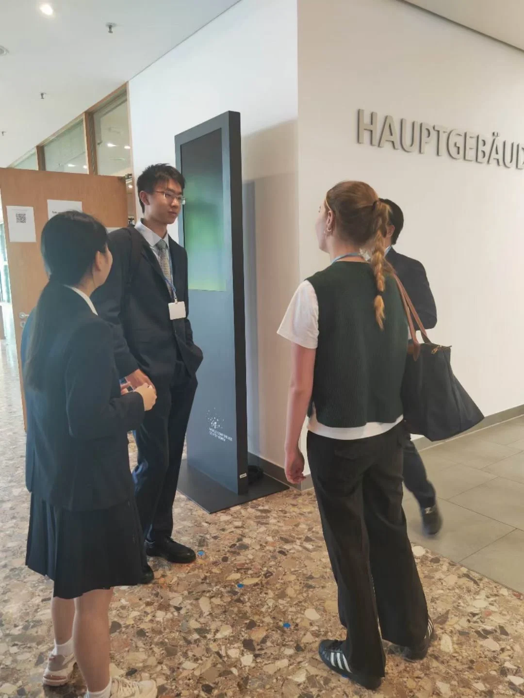 每个学生无论年龄大小都积极的在联合国会场跟各国官员，NGO代表，还有大...