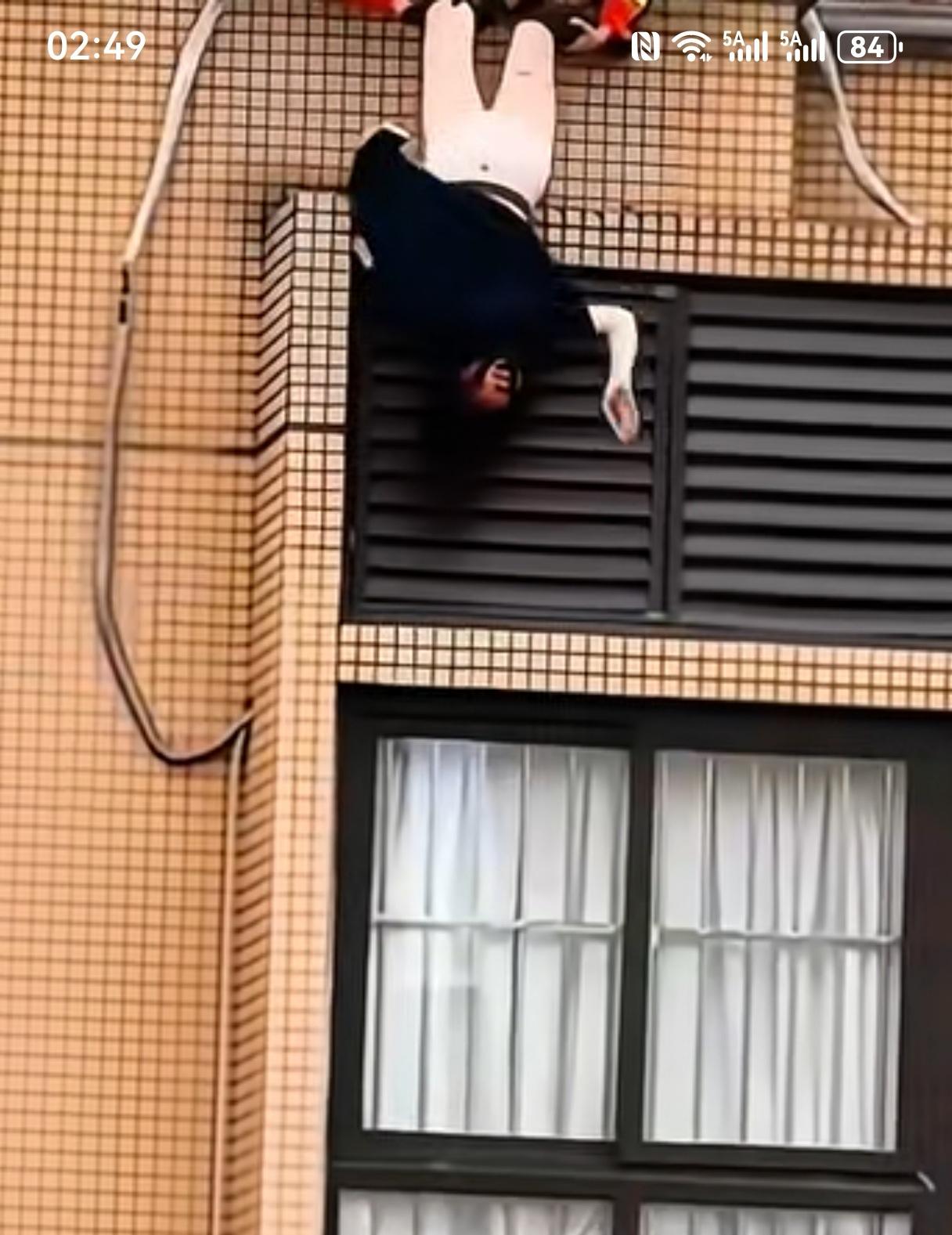 一个女士跳楼的视频。多位消防队员在楼顶拉住欲跳楼的女士，你再看看女士在干什么。