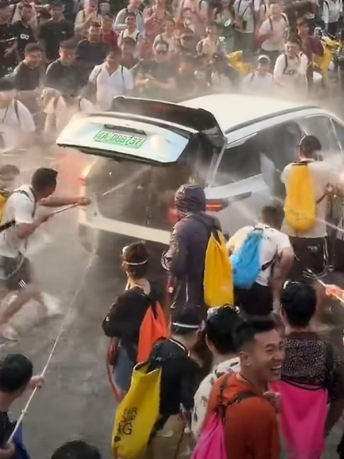 女子被强拉开车门泼水车内部冒烟 说实话，强行打开车门、强行往人家车里泼水，哪个都