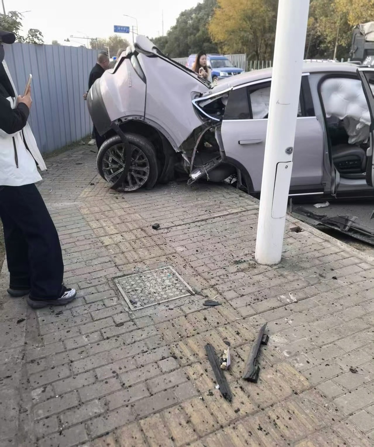 蔚来EC6，直接撞成两半了电池应该也没起火，这车主感觉也啥事儿没有，还坐在门槛上