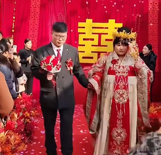 大衣哥的千金出嫁了，大衣哥夫妇默默的祝福爱女爱婿。
新娘子身着中式礼服，所戴的中