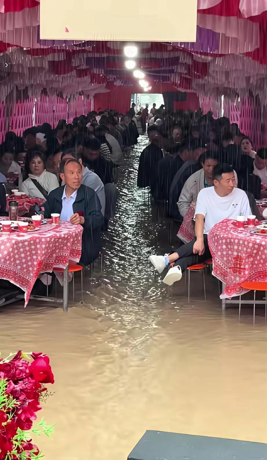 暴雨突袭婚礼现场，宾客淡定吃席，水漫金山也不改喜庆，这波操作太硬核了！