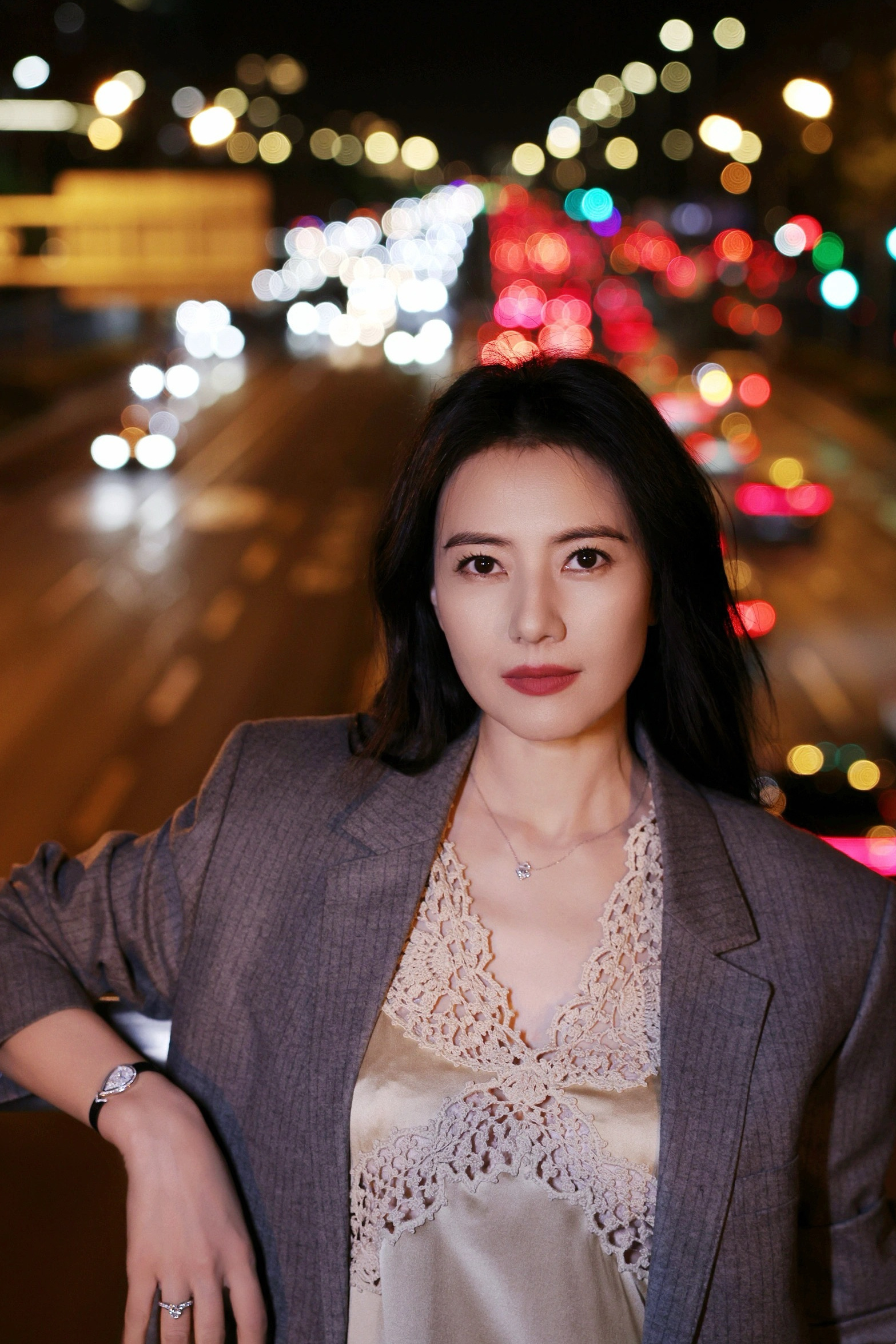 这组夜景街拍兼具松弛感与高级感。灰色西装的硬朗与蕾丝吊带裙的柔美碰撞出独特气质，