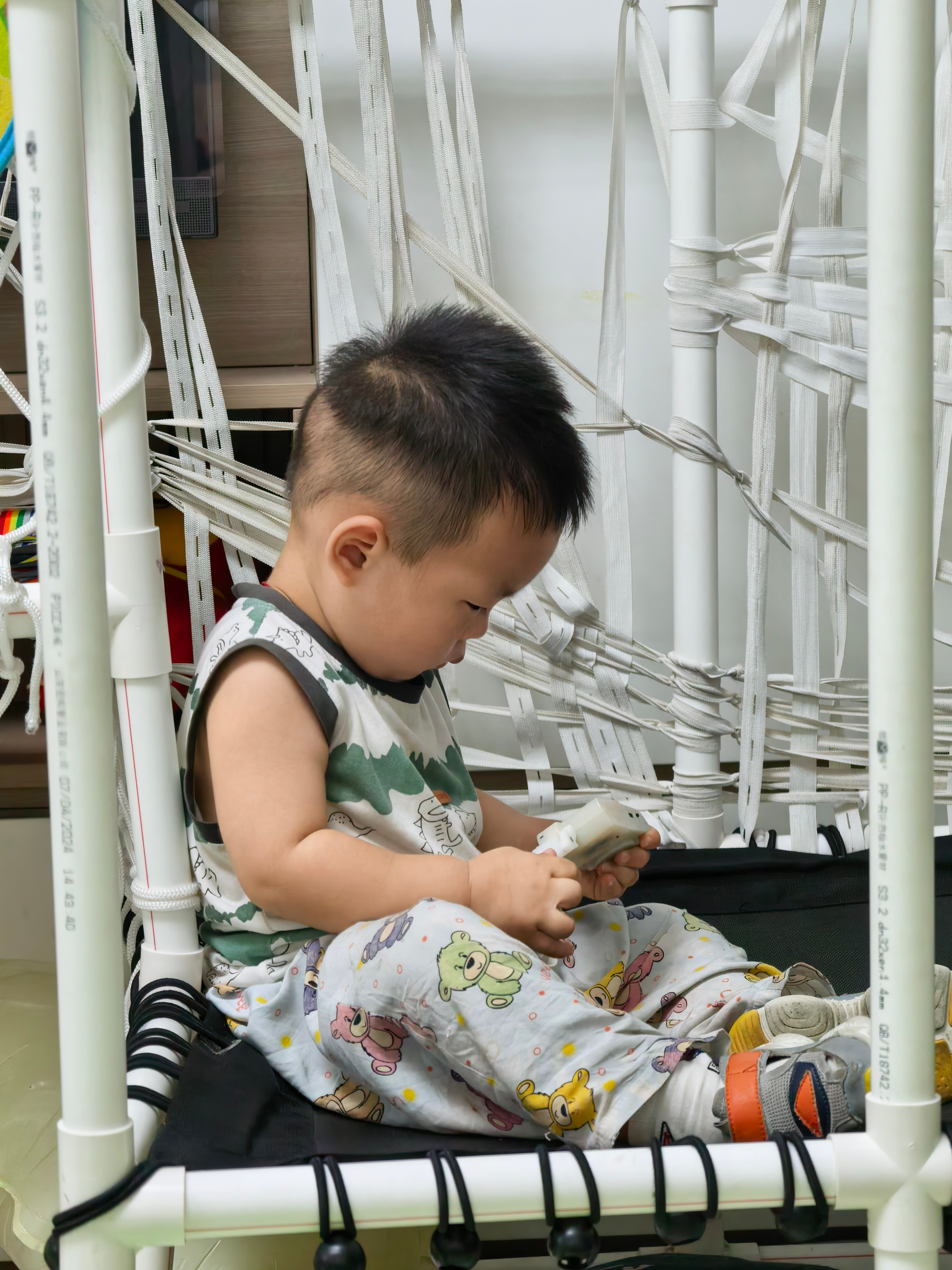 刚到家，这小子坐在蹦床上聚精会神的玩玩具，这专注度可以。不过我发现，乐乐最近好像