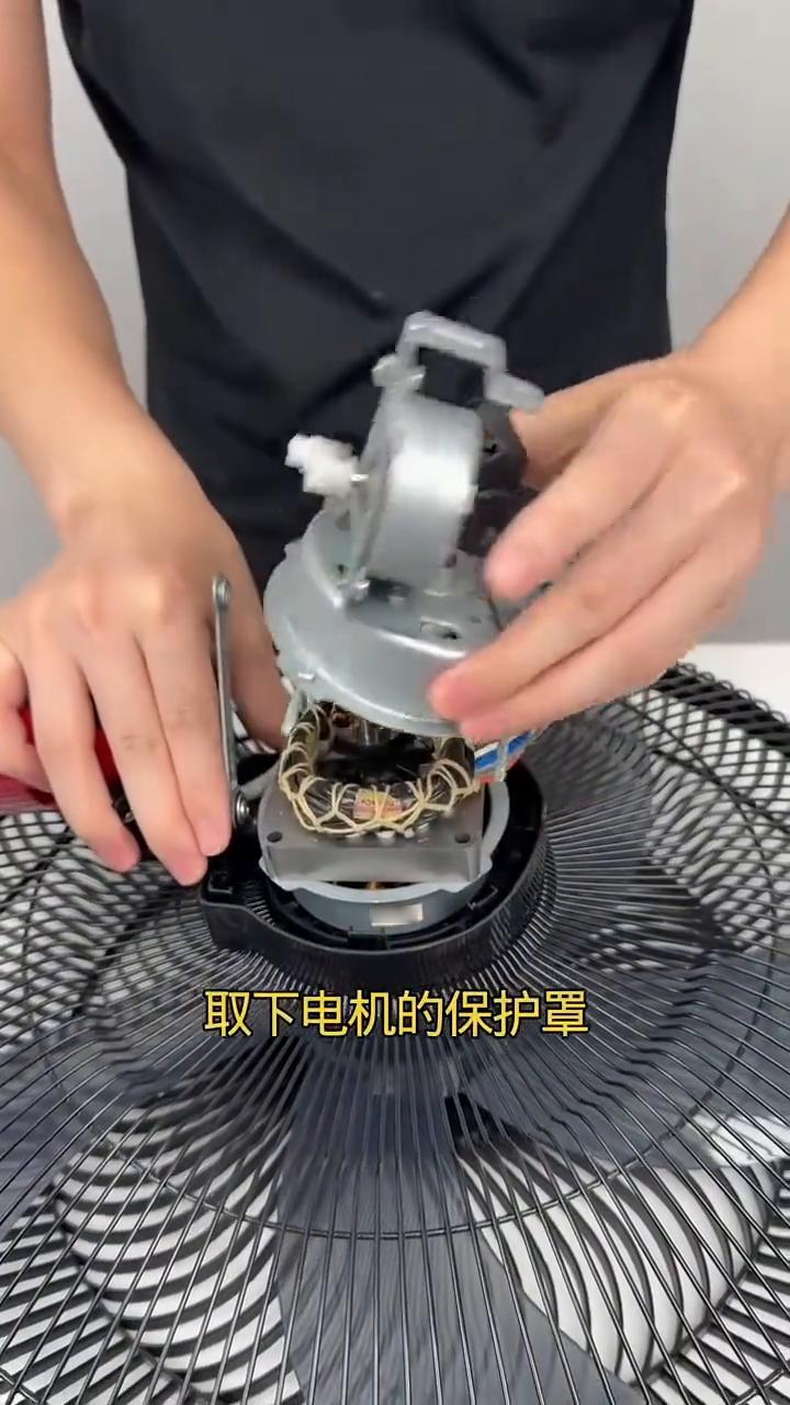 过来看，只要拧下后面这颗螺丝，打开外壳，取下电机的保护罩就能不花钱修好电风扇百分
