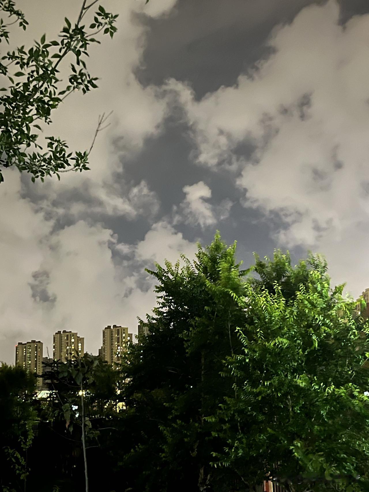 夜空中的云朵仿佛是天地间的精灵，轻轻盈盈地舞动着，它们的倩影装点着夜色的美丽。
