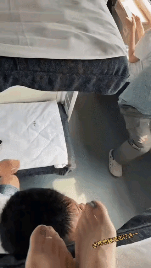 绿皮火车卧铺车厢里，下铺的白衣男在起来离开的时候，自己的上唇部位，也就是鼻子下端