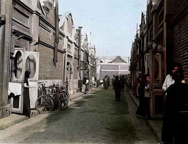 1938年，抚顺千金寨街道“妓院一条街”的景象，街道两侧的店铺鳞次栉比，不少女子