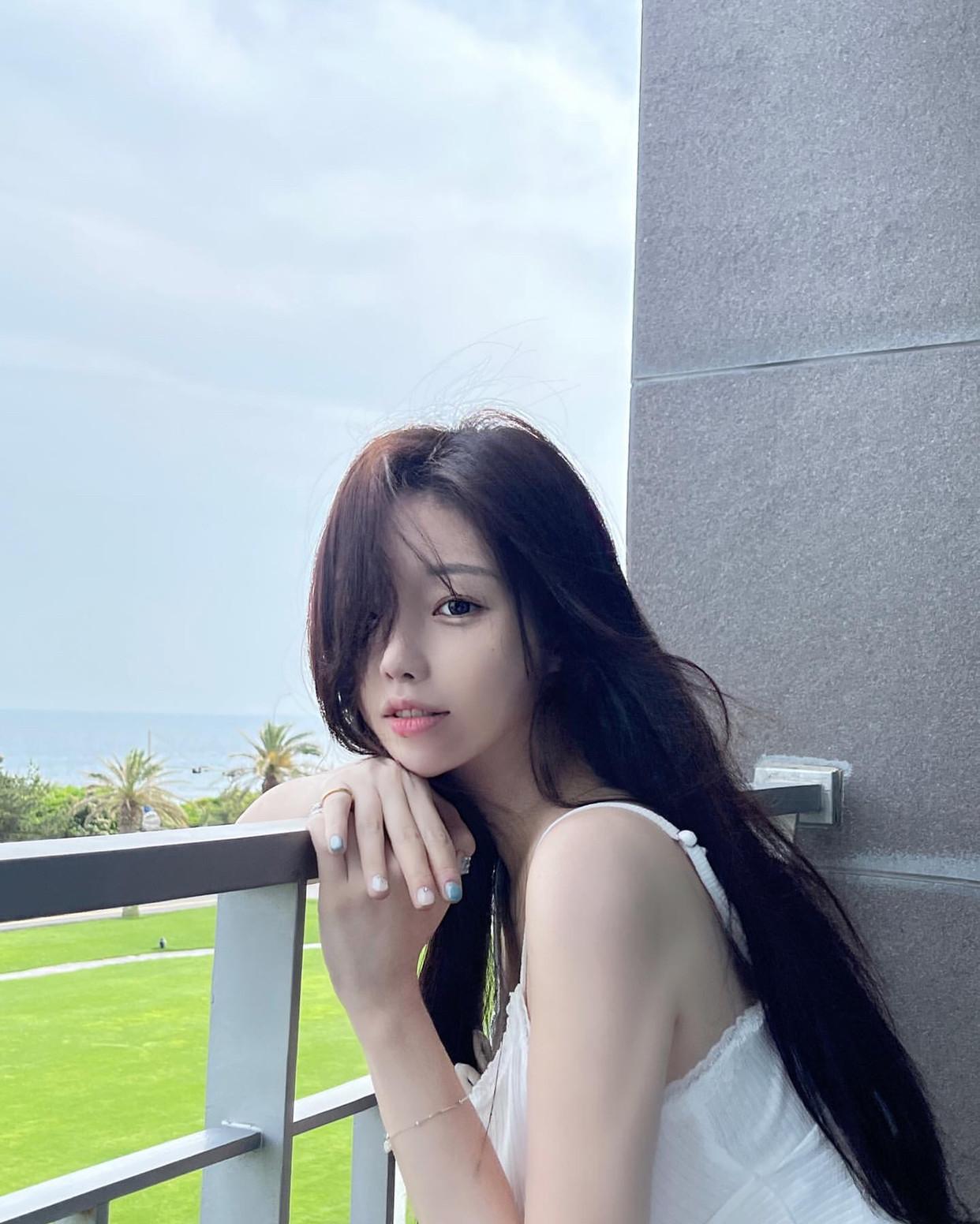 海边轻风拂面，少女倚栏沉思