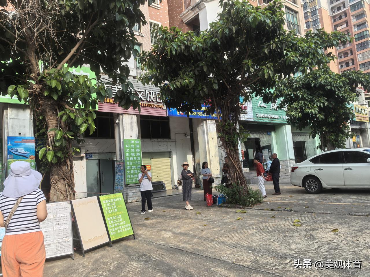 旅行社门口两拨不同渠道的客源，在等候同一辆旅游客车。