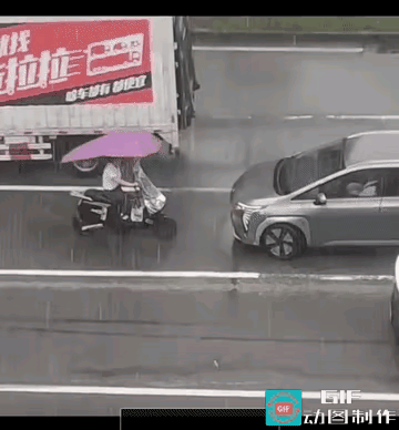 较上劲儿了？
如此对峙实属难得，从场面看小汽车反而处于下风，骑电动车带花棚子的女