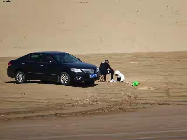贪图省事海水洗车，不料车子困在沙滩，真是得不偿失。

福建 ，一名男子开车到海边