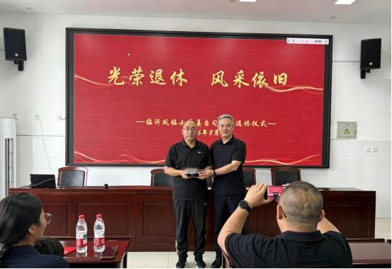 临沂凤临小学举行姜自习老师荣退仪式，赵配宝校长为姜自习老师送上荣退纪念品，教师代