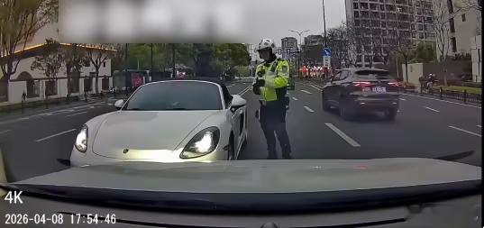保时捷车主当交警面威胁或被拘留保时捷车主恶意开远光灯，还违规越线逆行故意拦路。交