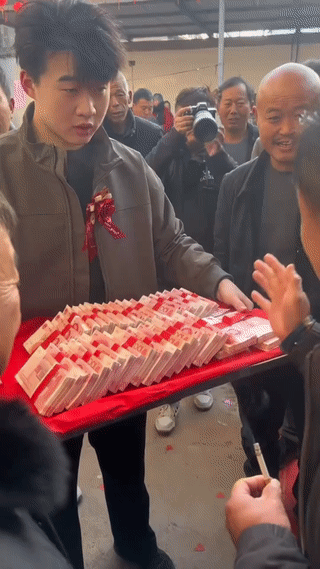 农村婚礼现场。
女方的家人正在清点男方送来的结婚彩礼钱。
看起来女方家是非常满意