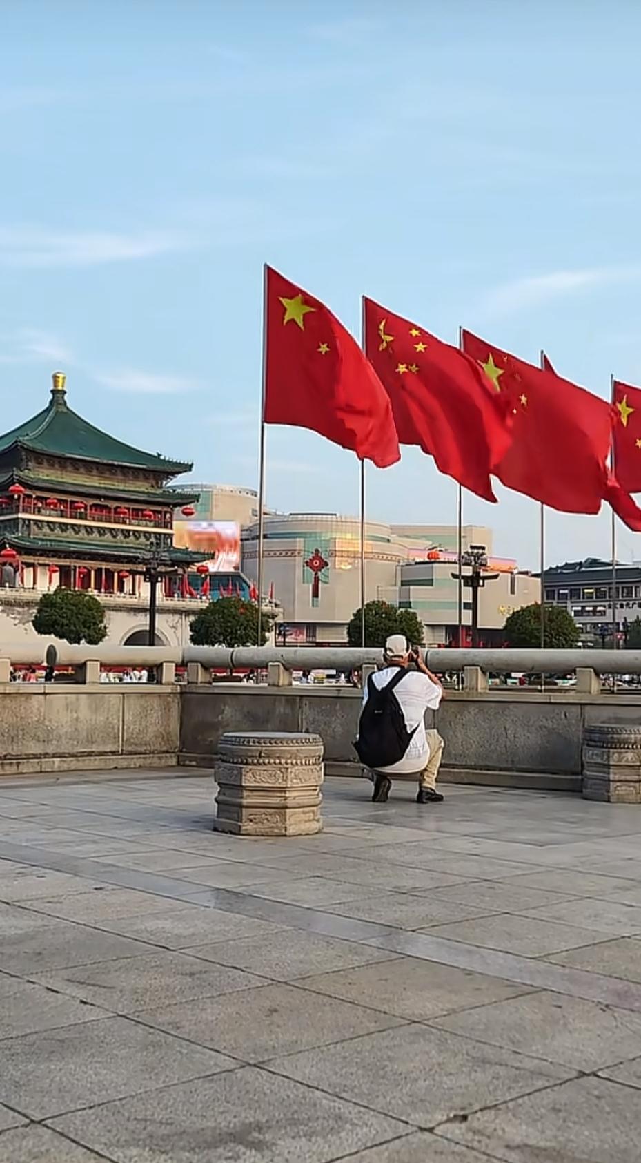 西安钟鼓楼广场红旗飘扬，国庆氛围已拉满街头迎风飘扬的五星红旗