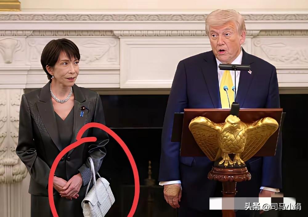 高市早苗毕竟是个女人，在如此隆重的记者招待会场合，她臂弯夹着一只小包，竟硬生生营