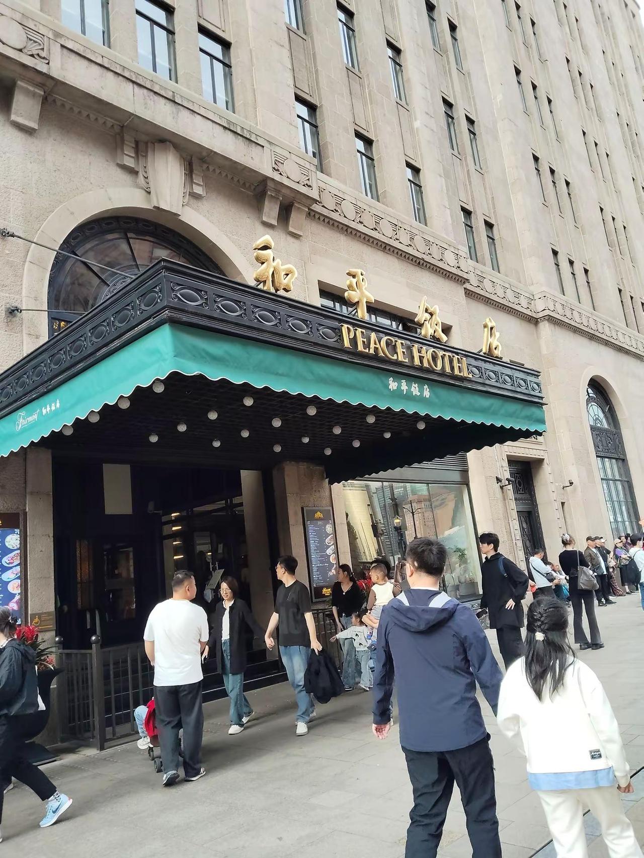 上海和平饭店的门槛实在太高了。我们本想进门用餐，刚走到门口就被工作人员拦了下来。