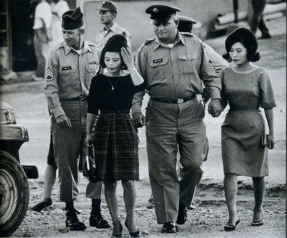 1952年韩国民宅，女子服务美军露出满意笑容，丈夫一旁愁眉不展。

她将硬币收入