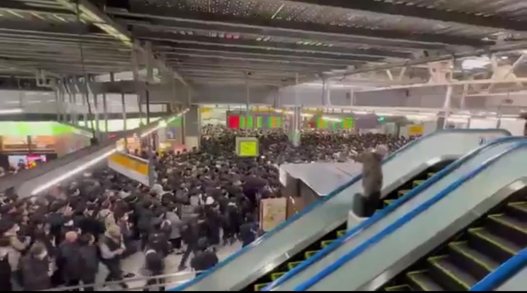 新闻快讯——东京早高峰交通因大面积停电陷入瘫痪，多条主要铁路线路停运。乘客沿轨道