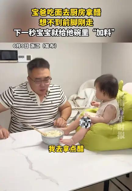 爸爸起身去拿醋，小调皮立刻找准机会，偷偷给面条“加餐”。小家伙模仿大人的模样有模