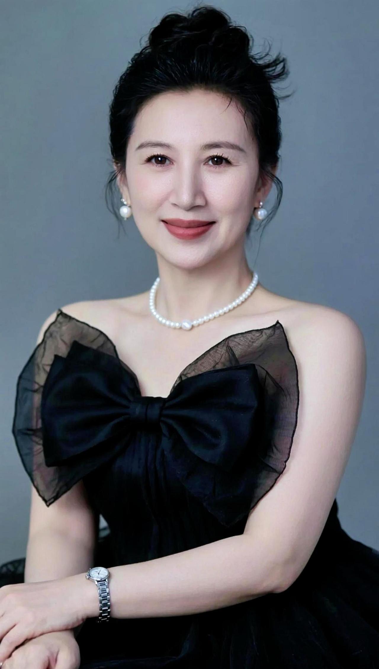 黑纱如夜，优雅如诗，珍珠项链点缀其间，仿佛月光洒落肩头。这是一场与自我对话的仪式