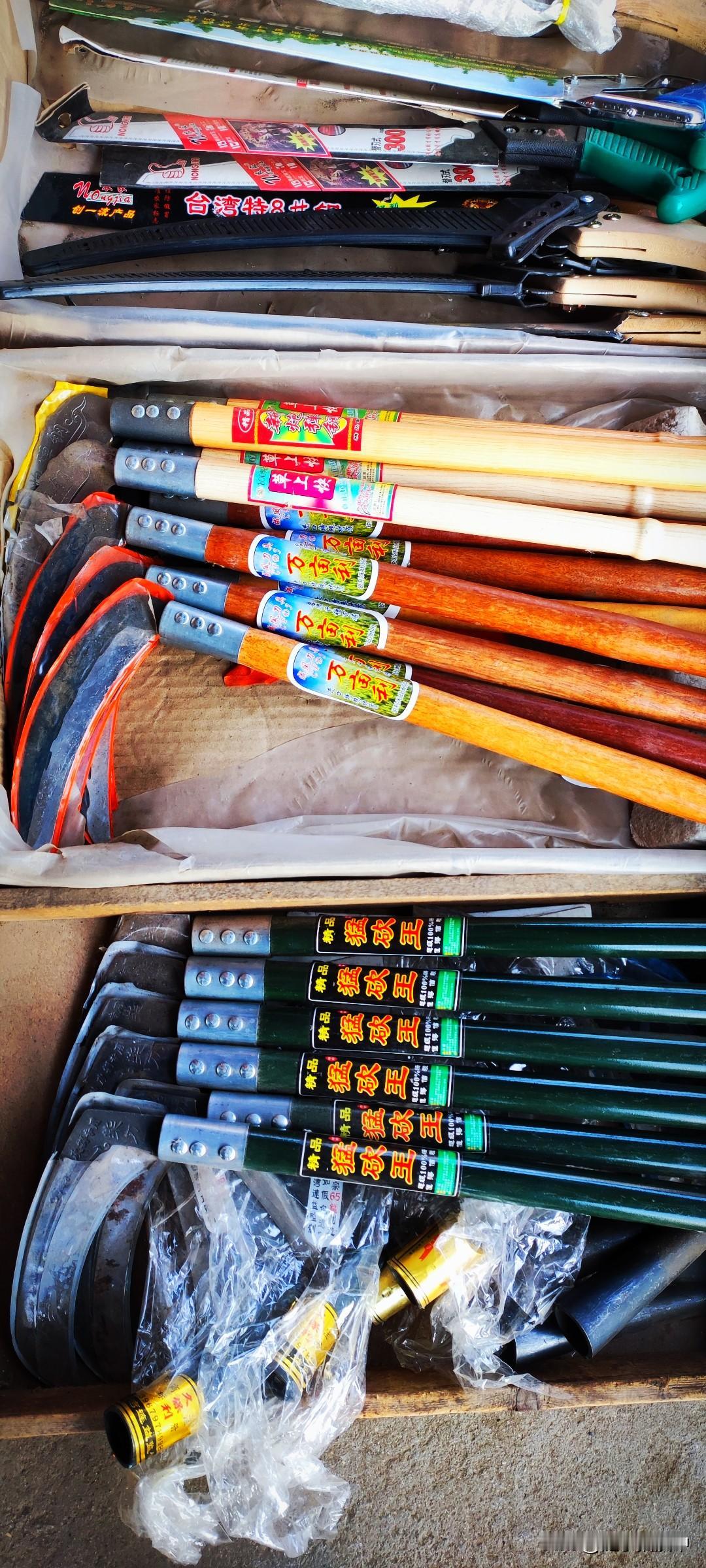 冬日生活打卡季杂货铺地上摊着一溜儿镰刀，“猛砍王”、“万亩利”、“草上快”，这些