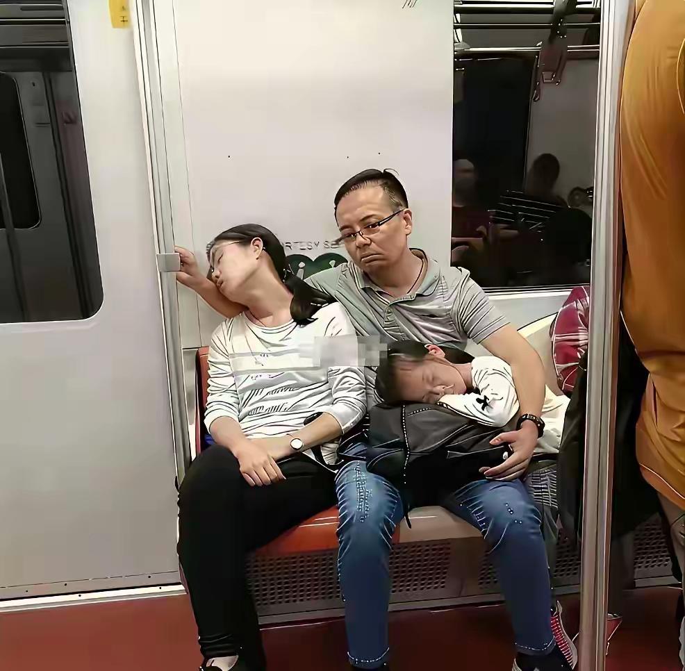 现在的男人真的很不容易！地铁上一个戴着眼镜的中年男人坐在座位上，目光呆滞的看着前